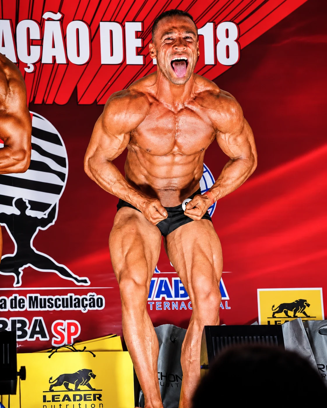 Fisiculturista de costas fazendo pose de duplo bíceps
